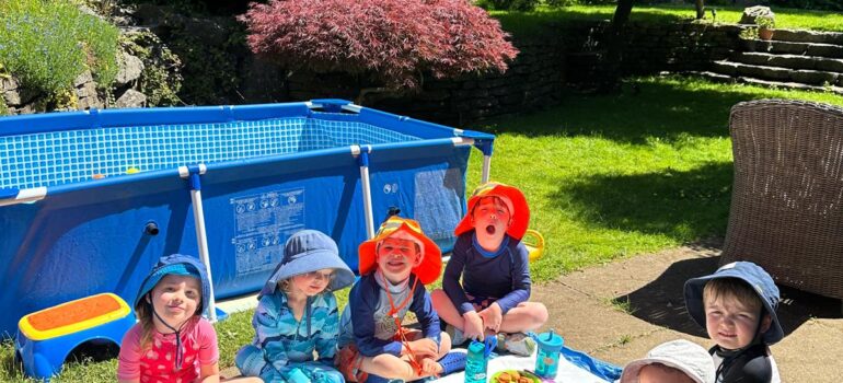 Daycare children wearing red hats and enjoying an outdoor wagon ride in North Vancouver