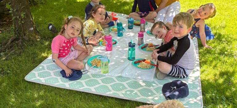 Children enjoying an outdoor picnic activity at Sweet House Daycare in North Vancouver